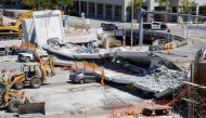 Workers remove debris from a collapsed pedestrian bridge at Florida International University in Miami, Florida, U.S., March 16, 2018. REUTERS/Joe Skipper
