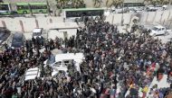 Syrian civilians, evacuated from rebel-held areas in the Eastern Ghouta, gather at a school in the regime-controlled Hosh Nasri, on the northeastern outskirts of the capital Damascus on March 16, 2018, ahead of being relocated to other areas. AFP / LOUAI 