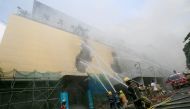 Firefighters douse water after a fire engulfed the Manila Pavilon hotel in Metro Manila, Philippines March 18, 2018. REUTERS/Romeo Ranoco
 