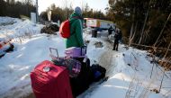 A man talks to a Royal Canadian Mounted Police (RCMP) officer before crossing the US-Canada border into Canada in Champlain, New York, U.S., February 14, 2018. Picture taken February 14, 2018. REUTERS/Chris Wattie