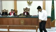Indonesian defendant I Putu Astawa, 25, walks in a court in Denpasar on March 26, 2018, befor being sentenced to 15 years in jail for stabbing an elderly Japanese couple to death during a botched burglary. AFP / Raka Yoda