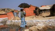 A Rohingya refugee man with child walks on a bamboo bridge to cross a water stream in Balukhali refugee camp, in Cox's Bazar, Bangladesh, March 21, 2018. Reuters/Mohammad Ponir Hossain


