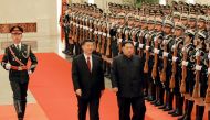 This picture from North Korea's official Korean Central News Agency (KCNA) taken on March 26, 2018 and released on March 28, 2018 shows China's President Xi Jinping (C) and North Korean leader Kim Jong Un (R) during the latter's welcoming ceremony at the 