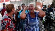 A relative of a prisoner cries in front of a police station in Valencia on March 28, 2018, after a fire engulfed police holding cells that resulted in the deaths of 68 people.  AFP / Katherine ORTIZ
