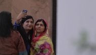 A journalist (L) takes a selfie with Pakistani activist and Nobel Peace Prize laureate Malala Yousafzai at the Serena Hotel where she is staying in Islamabad on March 30, 2018. AFP / Aamir Qureshi 