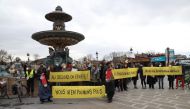 Demonstrators hold banners reading 