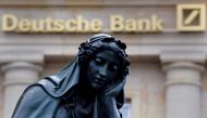 A statue is seen next to the logo of Germanys Deutsche Bank in Frankfurt, January 26, 2016. Reuters/  Kai Pfaffenbach