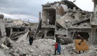People walk on rubble of damaged buildings in the besieged town of Douma, Eastern Ghouta, in Damascus, Syria March 30, 2018. (REUTERS/Bassam Khabieh)