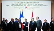 Fench President Emmanuel Macron (C) reacts during the International CEDRE Conference on April 6, 2018 in Paris. International donors are set to give the green light to a $10-billion investment plan for Lebanon at the conference in Paris, hoping to stave o