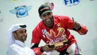 Saeed Al Sulaiti receives the winner’s trophy from Abdulrazak Al Kuwari, Secretary General of QMMF, at Losail International Circuit. BELOW: Al Sulaiti is seen in action while racing against Mashel Al Naimi and Nasser Al Malki. 