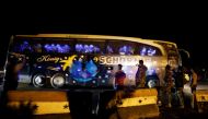 People and members of Syrian forces of President Bashar al Assad take pictures as a bus carrying freed hostages and rebels who were evacuated from the rebel-held city of Douma drives at Wafideen camp in Damascus, Syria April 8, 2018. Picture taken April 8