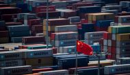 A Chinese flag is seen in front of containers at the Yangshan Deep-Water Port, an automated cargo wharf, in Shanghai on April 9, 2018.  AFP / Johannes EISELE
