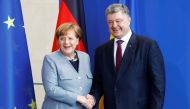 German Chancellor Angela Merkel and Ukrainian President Petro Poroshenko shake hands as they attend a news conference at the Chancellery in Berlin, Germany, April 10, 2018. REUTERS/Hannibal Hanschke
