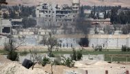 A picture taken on April 8, 2018, shows smoke billowing as Syrian Army soldiers advance in agricultural land on the eastern outskirts of Douma, as they continue their fierce offensive to retake the last opposition holdout in Eastern Ghouta.  AFP / STRINGE