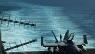 A sailor inspects atop an FA-18 hornet fighter jet during a routine training aboard US aircraft carrier Theodore Roosevelt in the South China sea on April 10, 2018. AFP / TED ALJIBE
