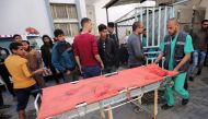 A picture taken outside the Najjar hospital in rafah shows a Palestinian paramedic pushing a blood stained stretcher which carried the body of a man who died in an explosion east of Rafah in the southern Gaza Strip, on April 14, 2018.  AFP / Said Khatib
