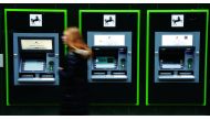 A woman walks past a row of cash machines outside a branch of Lloyds Bank in Manchester, Britain, February 21, 2017. Picture taken February 21, 2017. Reuters/Phil Noble