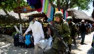 Forensic personnel and Mexican soldiers carry the corpse of a murdered man, who was found in Caletilla Beach, Acapulco, Guerrero state, Mexico on April 15, 2018.   AFP / Francisco Robles
