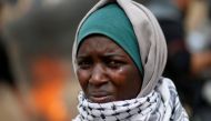 A woman demonstrator reacts to tear gas fired by Israeli troops during clashes at a protest at the Israel-Gaza border where Palestinians demand the right to return to their homeland, east of Gaza City April 20, 2018. Reuters/Mohammed Salem