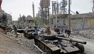 Destroyed tanks and armoured personnel carriers are pictured on a road in the Eastern Ghouta town of Douma on the outskirts of the capital Damascus on April 20, 2018, during an army-organised media tour. / AFP / LOUAI BESHARA