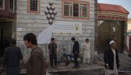 Afghan residents inspect the site of a suicide bombing outside a voter registration centre in Kabul on April 22, 2018.  / AFP / SHAH MARAI 