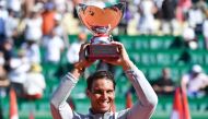 Spain's Rafael Nadal holds up the trophy as he celebrates his win over Japan's Kei Nishikori in their final match at the Monte-Carlo ATP Masters Series tournament on April 22, 2018, in Monaco.  / AFP / Yann COATSALIOU 
