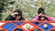 Syrian child refugees ride in the back of a pickup truck prior to their evacuation from the southern Lebanese village of Shebaa on April 18, 2018, to return home to their village of Beit Jinn in the southwestern Damascus countryside. / AFP / Ali DIA