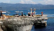 Workers stand on a rock formation that was turned into a mini park by West Cove resort, two days before the temporary closure of the holiday island Boracay in the Philippines April 24, 2018. Picture taken April 24, 2018. REUTERS/Erik De Castro