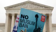 Protesters rally outside the U.S. Supreme Court, while the court justices consider case regarding presidential powers as it weighs the legality of President Donald Trump's latest travel ban targeting people from Muslim-majority countries, in Washington, D