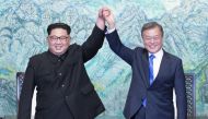 South Korean president, Moon Jae-in (R) and North Korean leader Kim Jong-un (L) are raising hands after issuing a joint statement in the Peace House building at the southern side of the truce village of Panmunjom, South Korea on April 27, 2018. Kim Jong-u