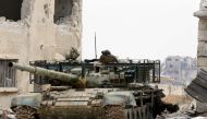 A picture taken on April 29, 2018, during a government guided tour in Damascus' southern al-Qadam neighbourhood, shows a Syrian army tank parked in a street during regime shelling targeting Islamic State (IS) group positions in Yarmuk, a Palestinian refug
