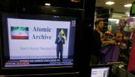 A hairdresser cuts a customer's hairs as Israeli prime minister's speech on Iran's nuclear program is broadcasted on televisions in Jerusalem on April 30, 2018.  AFP / Menahem KAHANA
