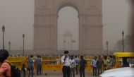 This photo taken on May 2, 2018 shows an Indian traffic policeman covering his face as he stands on duty during a dust storm in New Delhi. AFP / Chandan Khanna 