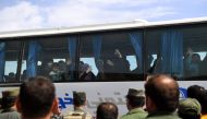 Syrian civilians from the area of Ishtabraq, where they had been held hostage since 2015, arrive on buses after being evacuated from the rebel area to the al-Eis checkpoint in Aleppo province on May 1, 2018. AFP / George Ourfalian 