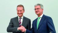 German carmaker Audi CEO Rupert Stadler (R) and Herbert Diess, chairman of the Audi supervisory board and CEO of carmaker Volkswagen (VW), shake hands prior to the Audi AG general meeting in Ingolstadt, southern Germany, on May 9, 2018. AFP / Christof Sta