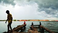 A boy walks through a damaged jetty as pre-monsoon clouds gather above the Vembanad Lake in Kochi, India, May 11, 2018. Reuters/Sivaram V



