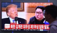 A man walks past a television news screen showing North Korean leader Kim Jong Un (R) and US President Donald Trump (L) at a railway station in Seoul on May 16, 2018.  / AFP / Jung Yeon-je 
