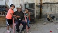 Mexican Manuel Garcia Hernandez, who claims to be 121 years old, sits with his great-granddaughters at his home in Ciudad Juarez, Chihuahua state, Mexico on May 16, 2018.  AFP / Herika Martinez