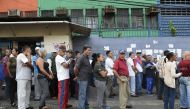 :Venezuelans queue outside a polling station as they wait to cast their vote during the presidential elections in Caracas on May 20, 2018 . AFP / Federico Parra
