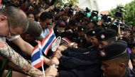 Demonstrators attempt to break thru a phalanx of police outside Thammasat University during a protest to mark the fourth year of junta rule in Bangkok on May 22, 2018. AFP / LILLIAN SUWANRUMPHA