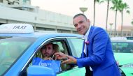 A staff of a Marriott Hotel in Qatar hands over Iftar kit to a cab driver.