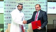 QFC and Commercial Bank officials shaking hands after the signing ceremony.