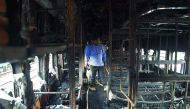 In a separate incident, Railway officials and policemen inspect a damaged carriages after a fire incident took place in a long distance train parked at the yard of Chatrapati Shivaji Terminal (CST), in Mumbai on May 29, 2018. AFP / Punit Paranjpe
