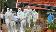 Doctors and relatives wearing protective gear dig a grave to bury a victim of the brain-damaging Nipah virus in Kozhikode, Kerala, India, May 24, 2018. Reuters/Stringer