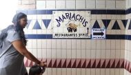 A woman and child walk past a sign pointing to the polling place at El Mercado de Los Angeles, in the Boyle Heights neighborhood, during the state's primary election on June 5, 2018 in Los Angeles, California. Mario Tama/Getty Images/AFP