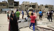 People collect usable belongings after an explosion near a mosque in Baghdad's Sadr City district, Syria on June 07, 2018. Murtadha Sudani - Anadolu
