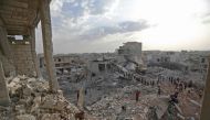 Syrians gather amidst destruction in Zardana, in the mostly rebel-held northern Syrian Idlib province, in the aftermath of following air strikes in the area late on June 8, 2018. AFP / OMAR HAJ KADOUR