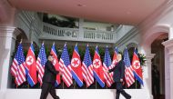 US President Donald Trump (R) and North Korea's leader Kim Jong Un (L) reach out to shake hands at the start of their historic US-North Korea summit, at the Capella Hotel on Sentosa island in Singapore on June 12, 2018. (Kevin Lim / The Straits Times / Ha