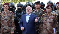 A handout picture released on July 9, 2016 shows Haider al-Abadi posing for a picture with army and counter-terrorism forces in the capital Baghdad (via AFP) 
