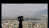 FILE PHOTO of a boy carrying bread on his head to sell on a hilltop overlooking Kabul April 20, 2015. Reuters 
